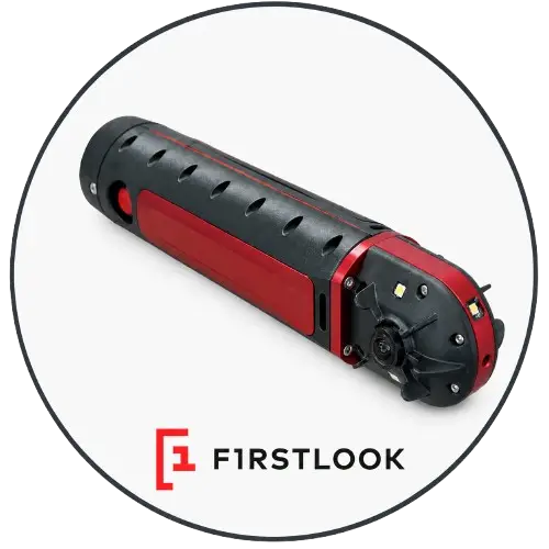 FirstLook compact throwable reconnaissance robot deployed by emergency responders into a hazardous building, rugged tracked design, camera system, lights, and remote inspection capability, realistic search and rescue operation, keywords: throwable robot, reconnaissance robot, tactical robot, tracked robot, remote inspection, hazardous building, search and rescue, public safety robot.